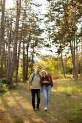 Obraz premium Couple enjoying a nature walk in a forest during the golden hour