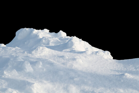 Huge snowdrift isolated on a black background. Natural snow texture.