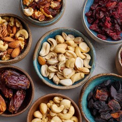 Assorted Nuts and Dried Fruits in Colorful Bowls on Gray Background