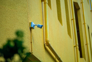 Security Camera on Bright Yellow Wall