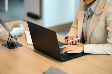 Cropped shot business women using laptop on workspace table