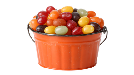 Mini pumpkin bucket overflowing with jelly beans, licorice, and chocolate coins, isolated on white background