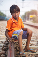 Young Poor Indian Boy Beside Railway Tracks in Slum Area