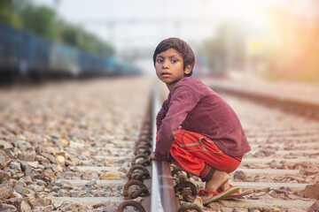 Young Poor Indian Boy Beside Railway Tracks in Slum Area