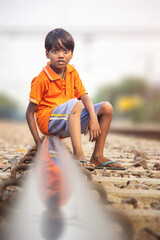 Young Poor Indian Boy Beside Railway Tracks in Slum Area