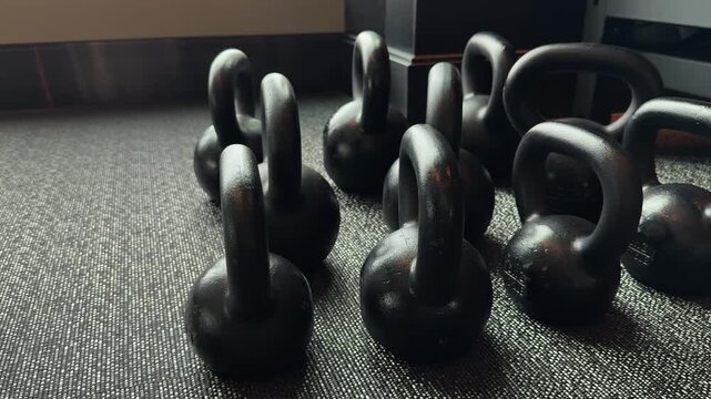 Row of black kettlebells on gym floor symbolizing strength training, endurance and modern fitness lifestyle