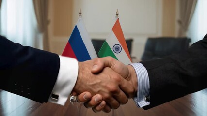 Dynamic handshake seals momentous Russia India international business partnership agreement in professional boardroom setting