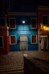 Burano, Italy - December 28 2025: Colorful Blue House Facade illumintade at Night on Fondamenta Terranova on Burano Island in the Lagoon of Venice.
