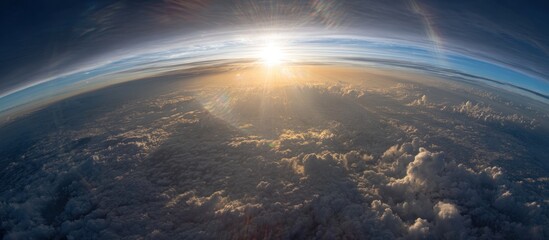 Curvature of the Earth, sunburst with scattered clouds, blue horizon line