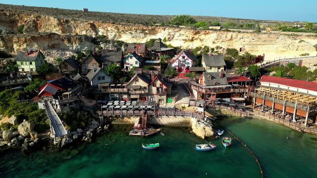 Drone aerial view at Popeye Village in Malta, the Mediterranean Sea, and the village houses near the beach.