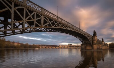 Fototapeta premium Old metal arch bridge over calm river at dawn