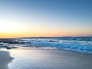 Obraz premium Sunset over Ocean Waves and Beach