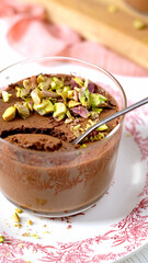 Eating rich chocolate mousse with pistachios