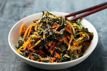 Wakame Seaweed Salad with carrot and zucchini in a bowl. Healthy food. © grinchh