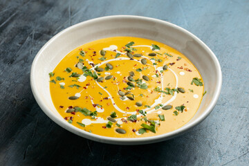 Pumpkin, butternut squash soup in white bowl