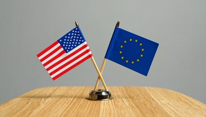 U.S. and EU table flags on wooden surface with gray backdrop—paired emblems evoke diplomacy, partnership, and symbolic dialogue in minimalist international composition.