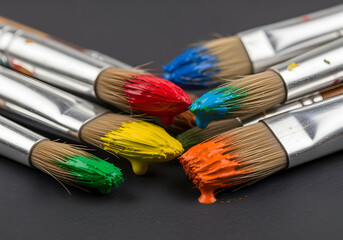 Fototapeta premium Closeup of Paint Brushes with Vibrant Colors on Dark Surface