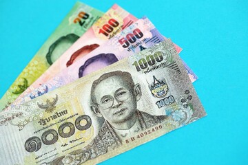 Thai baht money bills in big amount on blue. Finance and banking concept
