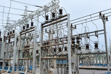 Detailed view of electrical connection system in high voltage substation, showing insulators, circuit components, steel frames, and transmission lines. Key setup for industrial electric grid operation