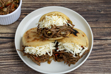 Delicious Venezuelan arepa stuffed with shredded beef and cheese, a traditional Latin American street food dish