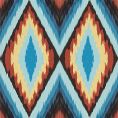 Seamless geometric pattern with diamond shapes in blue orange and yellow tones creates vibrant ethnic textile background
