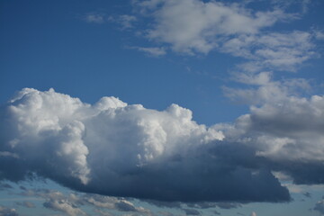 Fluffy white-gray clouds in the blue sky. Background