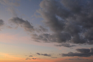 Beautiful evening sky with orange rays of sun and gray clouds
