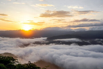 The white mist on the sea waves floats on the top of the high mountain. The morning sunlight shines through, looking warm and refreshing.
