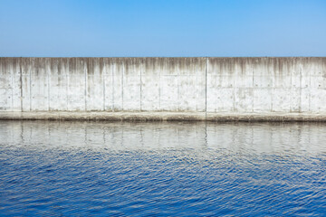 青空と堤防のある汽水域