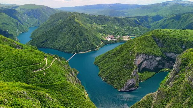 Aerial view of the picturesque Piva River canyon with the turquoise waters of Piva Lake surrounded by steep rocky slopes in Montenegro.The summer landscape is perfect as a travel and nature background