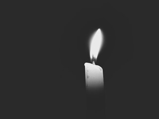 burning candle on darkness black and white image 