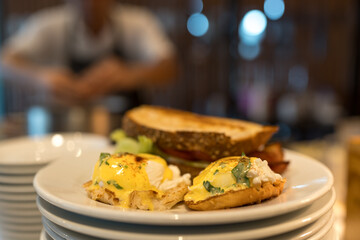 Two eggs benedict sandwiches on a plate. Close up