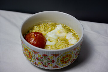 A Hot Bowl of Instant Ramen with a Poached Egg and Tomato Topping