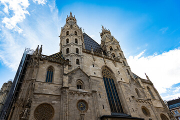 Fototapeta premium Gothic St Stephen's Cathedral With Twin Towers Lit by Bright Blue Sky in Vienna Austria