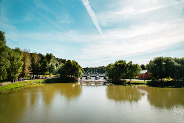 A pond with a dam and a bridge against the blue sky on a clear sunny day. Nature lake landscape...