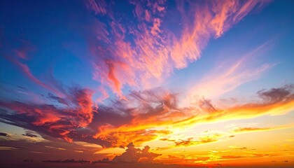 Fototapeta premium Dramatic Sunset Sky with Pink and Orange Clouds Against Blue Backdrop Glowing Fiery Cloudscape Sunlight and Vibrant Colors Nature's Beauty Breathtaking Scene