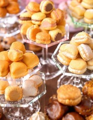 Assorted small pastries and cookies on tiered glass stands