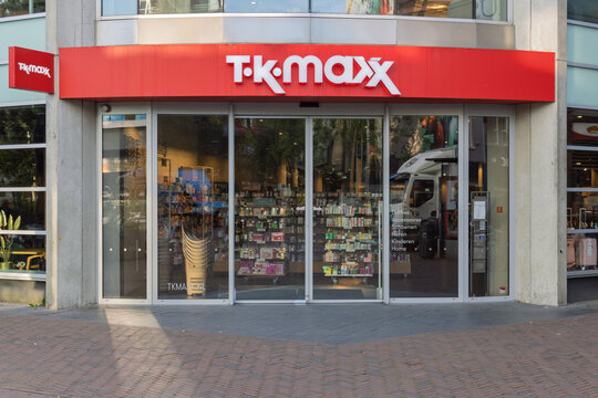 The storefront of a TK Maxx store with its red and white sign. The large glass windows show the variety of products inside.