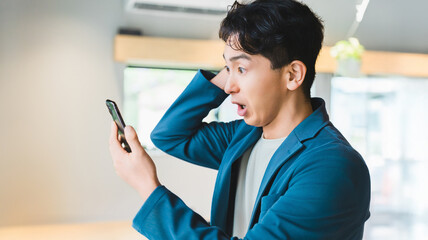スマートフォンを見て驚く男性ビジネスマン