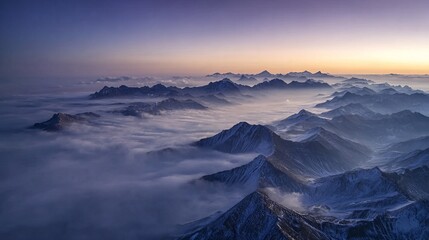 Snow-capped mountain peaks rising above a sea of clouds at dawn