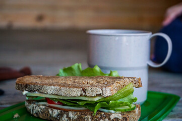 packed lunch with sandwich and cup and child  in the background