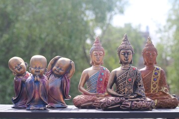 Esculturas artesanais budistas expostas em feira de rua
Handcrafted wooden sculptures displayed at street market