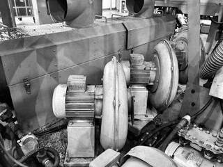 Industrial air blower system with electric motors in a factory. The blowers are used for ventilation, dust collection, or material transport in manufacturing processes. The image highlights the mechan