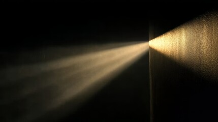 Beam of light illuminating a dark space, casting a focused glow on a textured surface