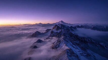 Snow-capped mountain peaks rising above a sea of clouds at twilight