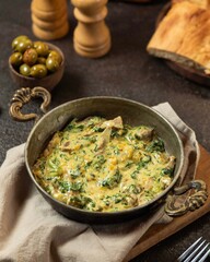 Delicious savory dish with greens and cheese served in a rustic setting with bread and olives