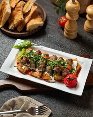 Delicious kebabs served with bread, fresh vegetables, and herbs on a rustic table