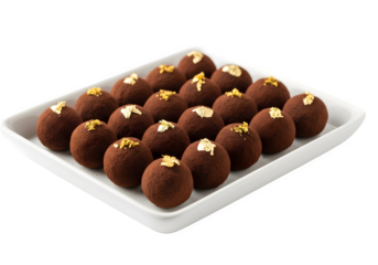 A tray of chocolate truffles adorned with gold leaf, isolated on transparent background, representing luxury and indulgence in confectionery