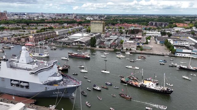 Amsterdam, Netherlands 23 August 2025: Drone footage of Sail 2025 - Sailing Parade in Amsterdam. Enjoy the view of the sail boats by the docks and in the canals of Amsterdam from a Birds Eye view
