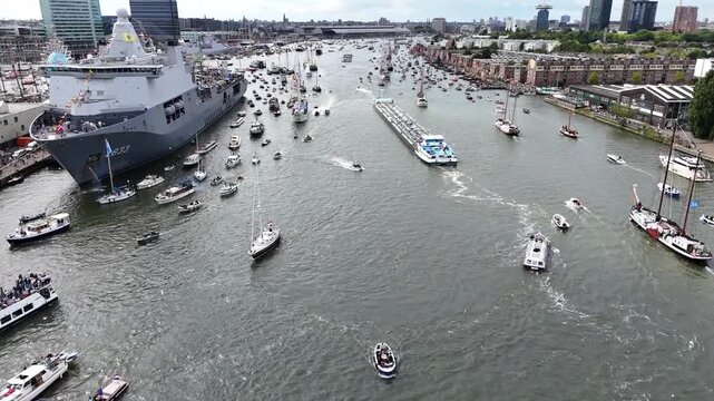 Amsterdam, Netherlands 23 August 2025: Drone footage of Sail 2025 - Sailing Parade in Amsterdam. Enjoy the view of the sail boats by the docks and in the canals of Amsterdam from a Birds Eye view